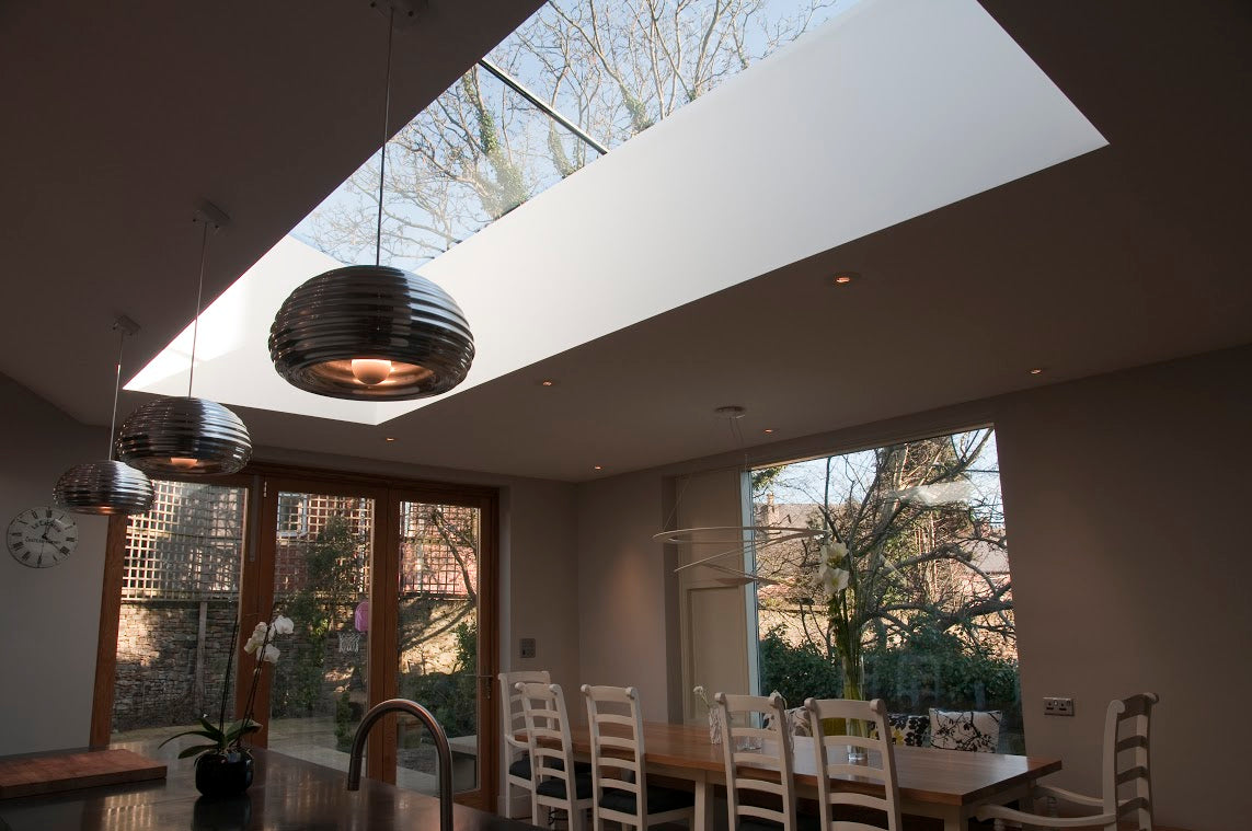 flat rooflight installed in a kitchen with grey counter tops and doors leading to the garden