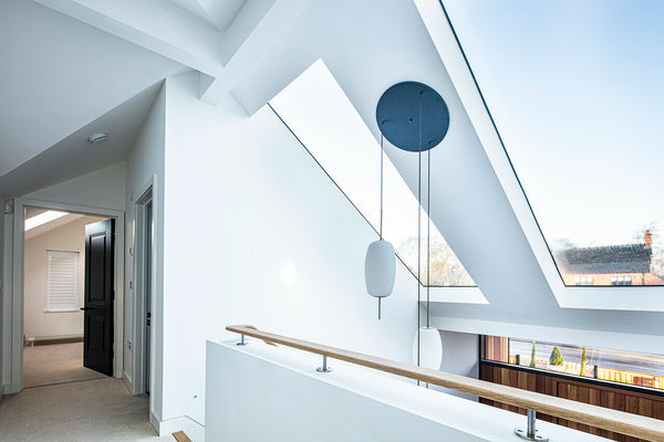 White modern hallway with two roof windows looking out to the driveway, bedroom off to the left