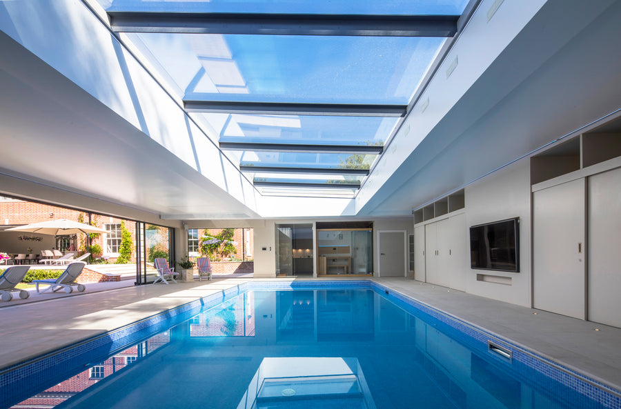 multi part flat rooflight installed above a blue swimming pool in a garden room