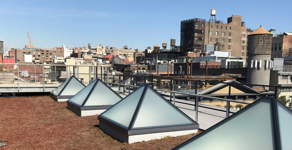 pyramid rooflights with clouded glass installed on a brown flat roof in the city